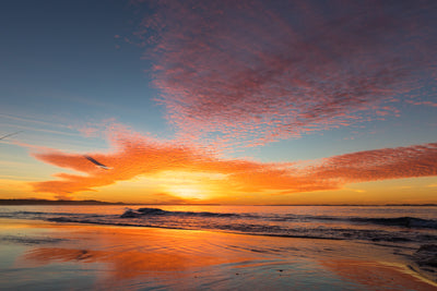 amazing sunset at the beach with red and orange colours and cloud formation resembling an eye